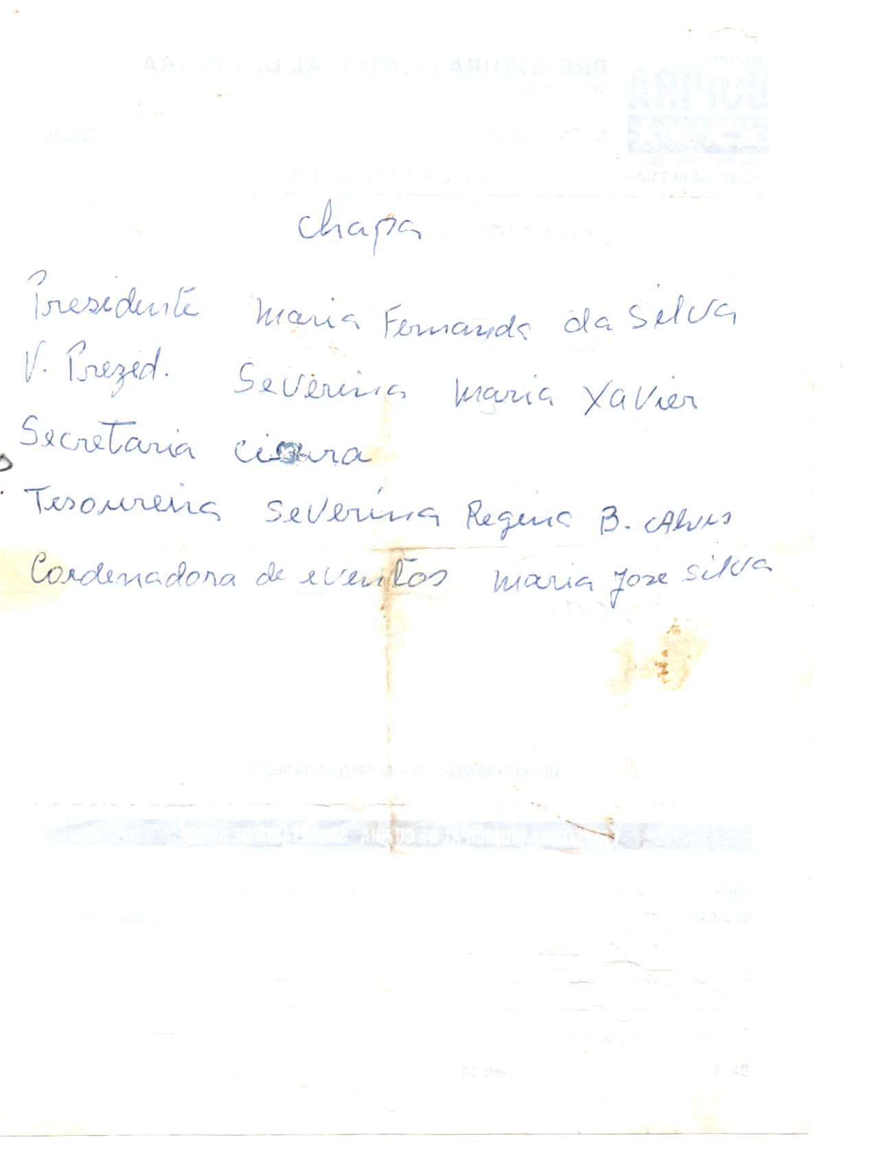 Anotações pessoais Zefinha em eventos e viagens em folha de papel branco, com leve desgaste e pequenas manchas amareladas no meio do papel.  Nele, há um texto em caneta azul, manuscrito em letra cursiva, organizado com o título centralizado “chapa” e a lista de participantes um abaixo do outro.
Informações textuais:
Presidente: Maria Fernanda da Silva
V. Presid: Severina Maria Xavier
Secretária: Cícera
Tesoureira: Severina Regina B. Alves
Coordenadora de eventos: Maria Jose Silva
