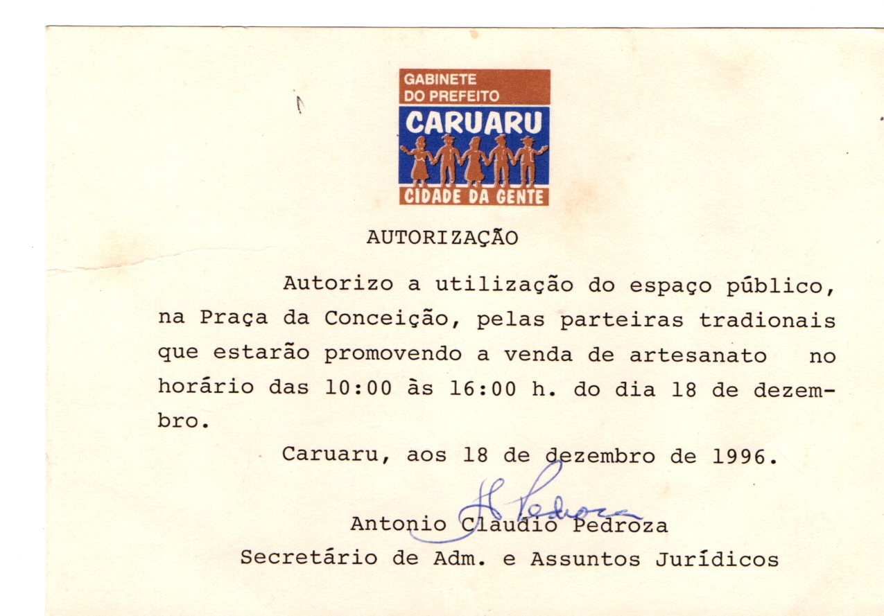 Autorização para uso do espaço público, na Praça da Conceição, para a venda de artesanato pelas Parteiras Tradicionais, em papel retangular, amarelo claro. Na parte superior, centralizado, tem um logotipo retangular, colorido, do gabinete do prefeito. O texto está em letra de imprensa e a assinatura centralizada em caneta azul logo abaixo do texto.
O logo é composto por três faixas retangulares, a do topo é marrom e tem em letras brancas “Gabinete do prefeito”, a do meio é azul, tem em letras grandes e brancas a palavra “CARUARU” e logo abaixo, cinco figuras humanas estilizadas, lado a lado e de mãos dadas que lembram o artesanato do Mestre Vitalino. As figuras humanas são marrons e não têm rosto aparente. Algumas pessoas usam chapéus, calças, camisas  e outras usam vestido.
Na faixa marrom inferior, em branco: “CIDADE DA GENTE”.
Abaixo, o texto datilografado com as seguintes informações:
AUTORIZAÇÃO
Autorizo a utilização do espaço público, na Praça da Conceição, pelas parteiras tradicionais que estarão promovendo a venda de artesanato no horário das 10:00 às 16:00 h. do dia 18 de dezembro.
Caruaru, aos 18 de dezembro de 1996.
Assinatura de Antônio Cláudio Pedroza
Secretário de Adm. e Assuntos Jurídicos
