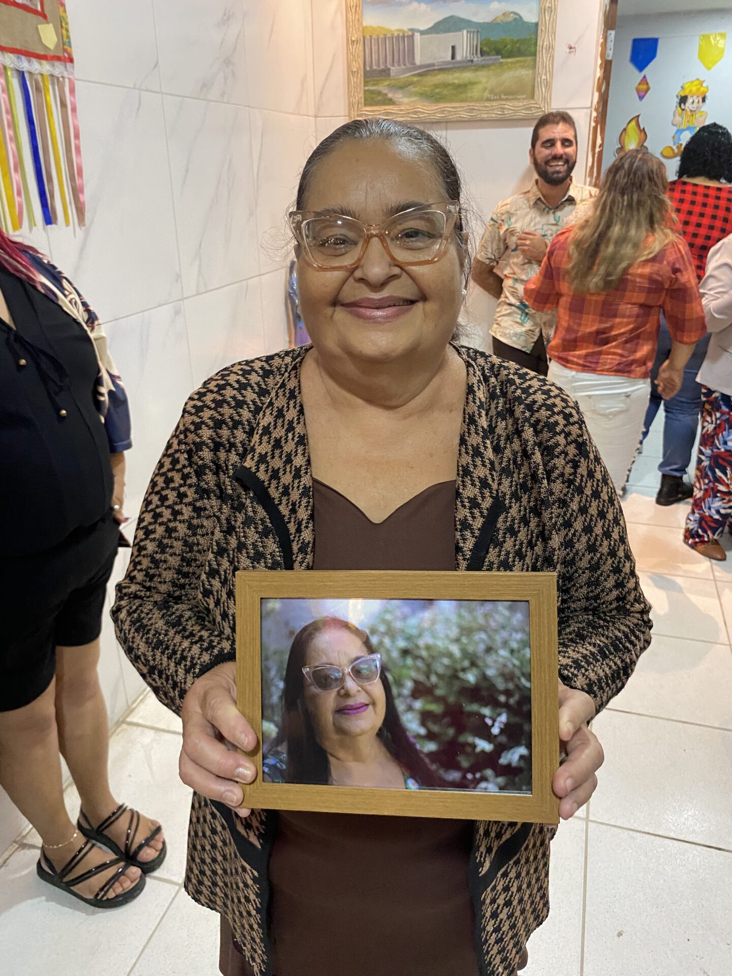 Parteira Elisabete recebe sua foto impressa em um porta retrato